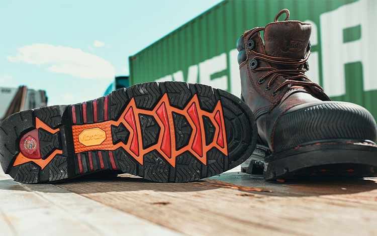 Pair of Justin Warhawk nano comp toe lace up boots in brown